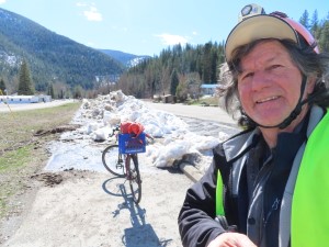 Ted and his bike with snow piled up near Mullan, Idaho. (end of the Trail of Coeur d’Alene)