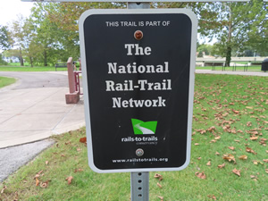 Rail-trail sign next to Cardinal Greenway bike trail near Muncie, Indiana.