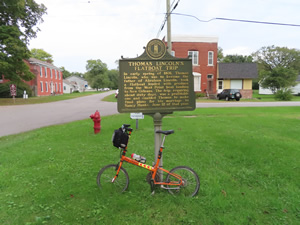 Ted’s bike on historic sign related to Abraham Lincoln’s father in West Point, Kentucky.