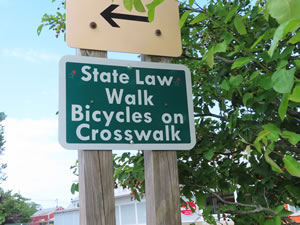 Sign on the Cape Code Rails to Trails in Massachusetts. – Most people do not walk their bikes when crossing the road.