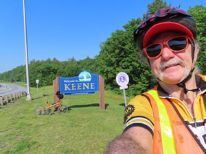 Ted with his bike on sign for Keene, New Hampshire.