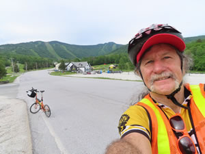 Ted and his bike with ski area in Killington, Vermont.