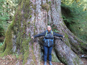 Marty next to tree on river trail in the Hoh rainforest.