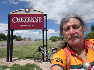 Ted with his bike at entering Cheyenne, Wyoming sign near the Walmart where he parked his car.