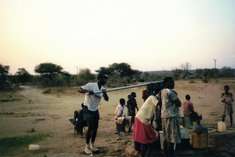 Shingi pumping water by the school at Sianzyundu.