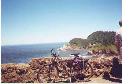 Ted's bike at viewpoint on highway 101 with view of Heceta Head lighthouse in the background.