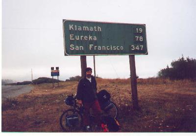 Ted and his bike at a road sign off highway 101 just South of Crescent City, California.