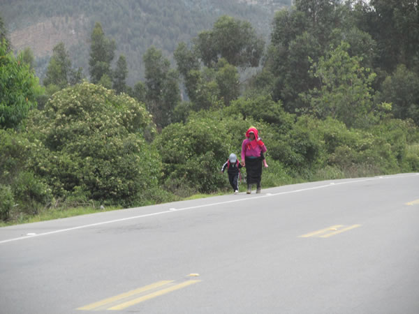 People walking along highway in Andes Mountains, Ecuador.