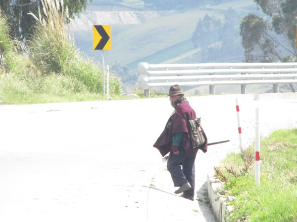 Man walking along highway in the Andes mountains of Ecuador.