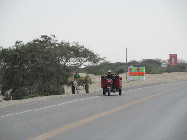 Vehicles on highway in desert between Piura, Peru and Chiclayo, Peru.