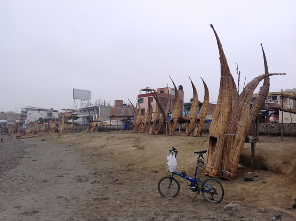 Ted’s bike with straw fishing boat on the beach of Huanchaco, Peru.