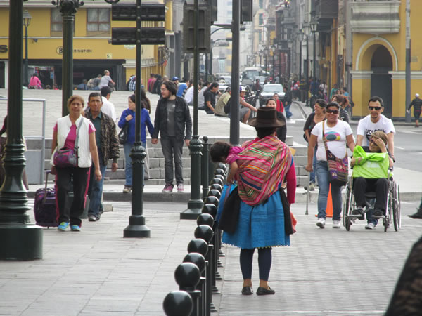 A lady carrying her child in historic center of Lima, Peru.