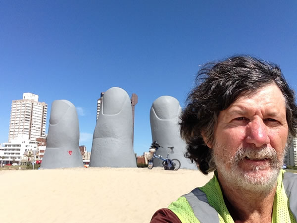Ted and his bike at the “Hand in the Sand” in Punta del Este, Uruguay.