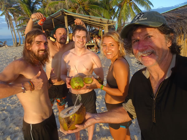 Ted drinking coconut drink on a single family San Blas Island, Panama with adventure team members. (first night)