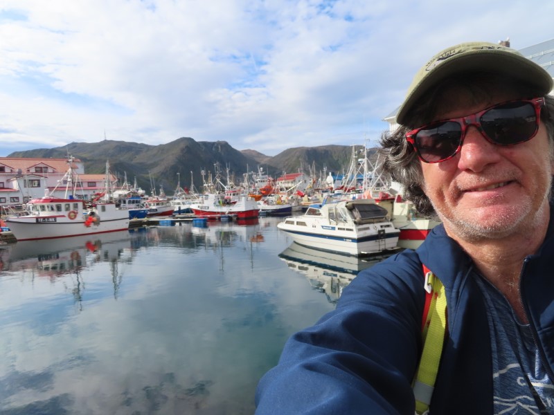 Ted in town of Honningsvg, Norway with boats in the harbor.