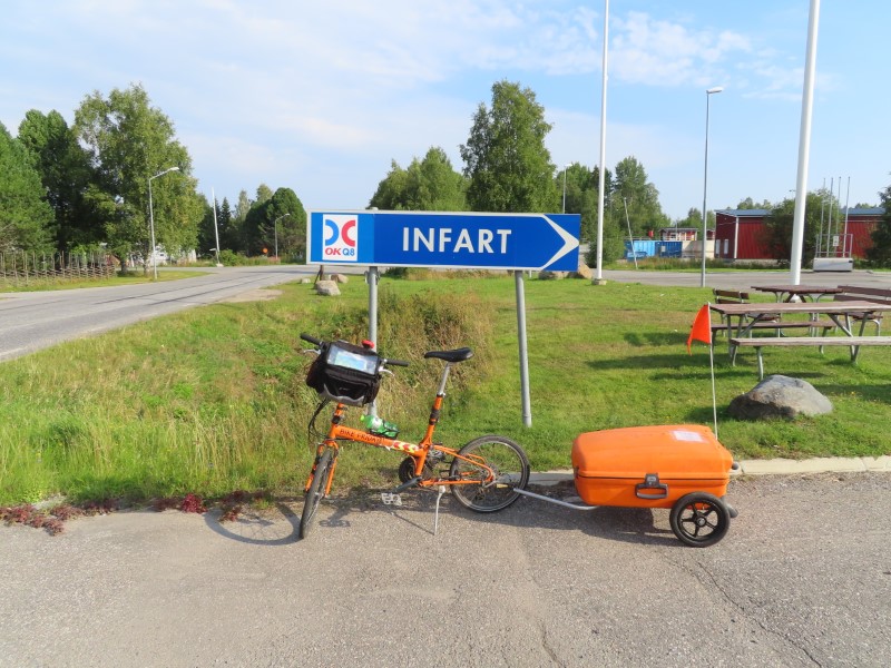 Ted’s bike in front of gas station entry sign in Sweden.