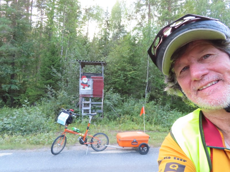 Ted with his bike on road with tower (saw a lot of these, I think they were for logging) south of Fllfors, Sweden.