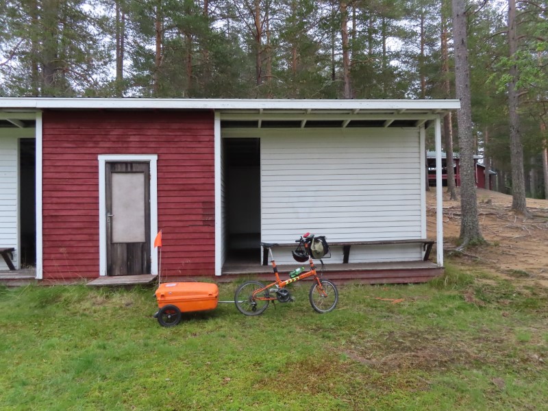 Teds bike in front of the lake changing room where he slept at Sanabadets campground in Sweden.