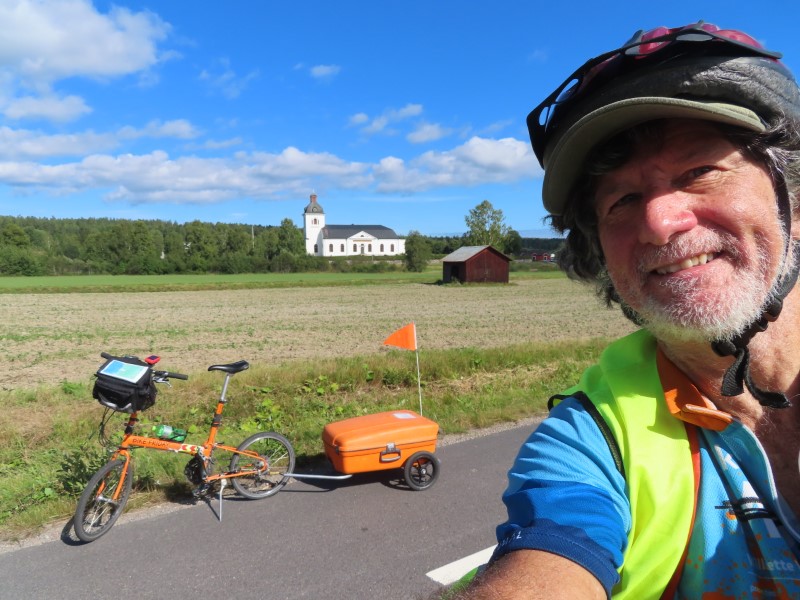 Ted with his bike on road between Iggesund, Sweden to Kllene, Sweden.  The church is near Norrala Bygdegrd.