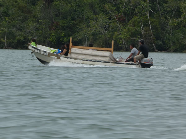 People moving a bed on the Rio Dulce between the town of Rio Dulce and Livingston, Guatemala.