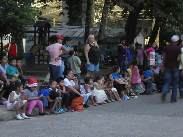 Children waiting for the parade to go through Rio Dulce, Guatemala.