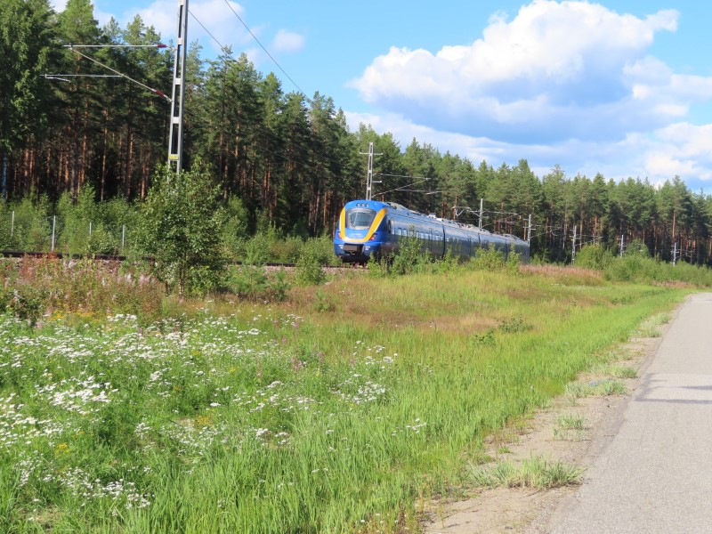Passenger train next to highway 331 between sng, Sweden and Srberge, Sweden.